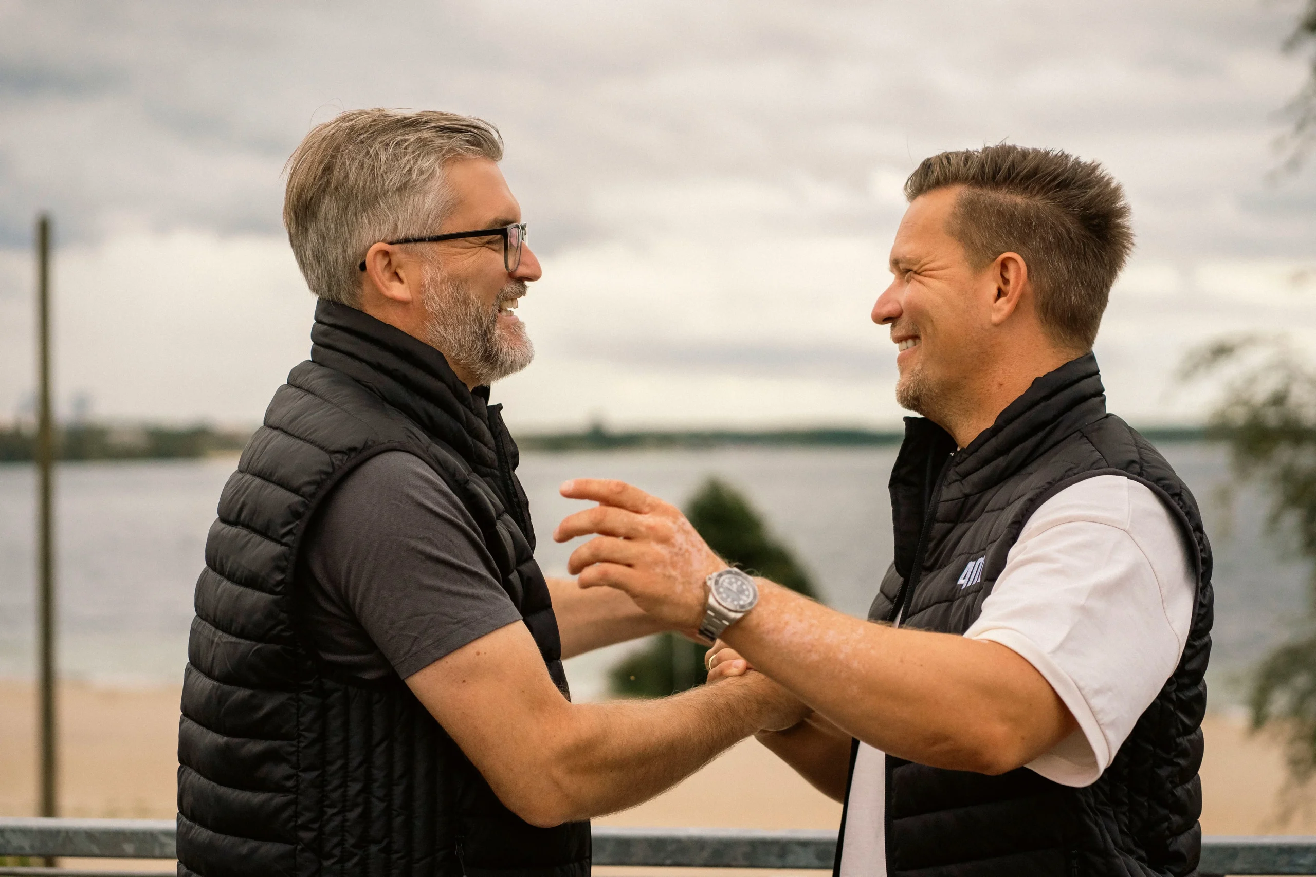 4M-Geschäftsführer lachend beim Shake-Hands